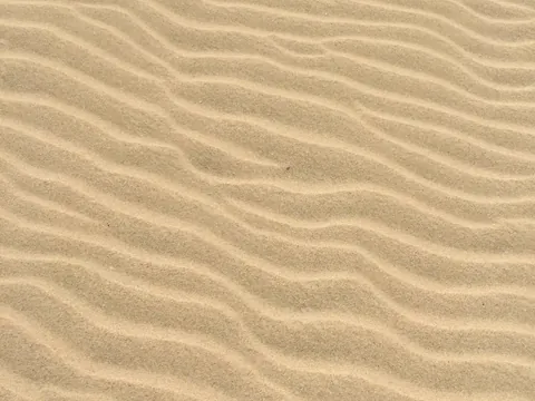 Feine Wellen im hellen Sand